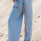 Model showcasing Bella Road Drawstring Wide Leg Jeans in medium blue, featuring a trendy drawstring waist and wide leg design.