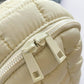 Close-up of cream Bella Road Quilted Nylon Crossbody Bag with durable zippers, perfect for fashion-forward adventures.