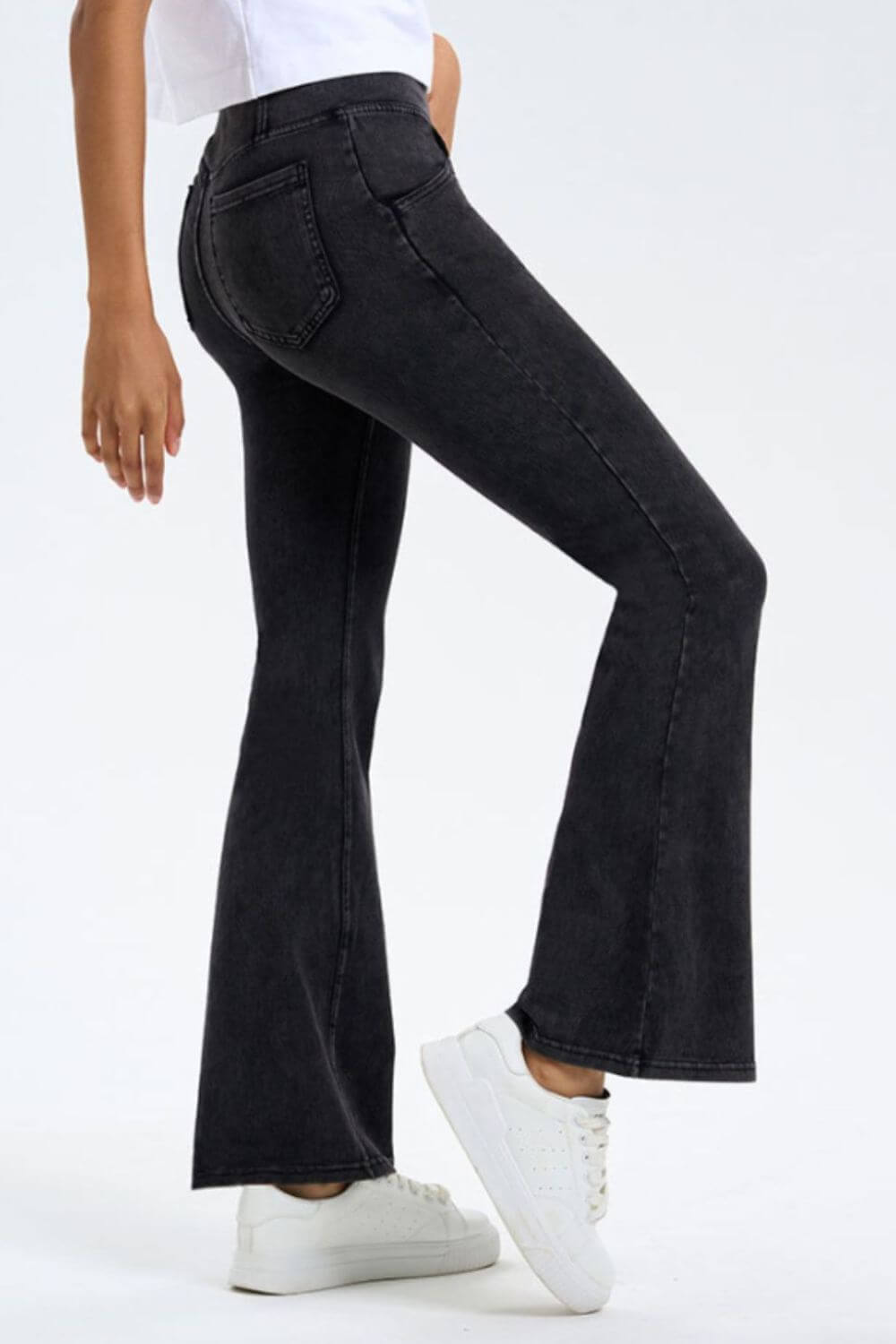 Model showcasing Basic Bae Pocketed Highly Stretchy Bootcut Jeans in black, featuring a flattering fit and stylish design.