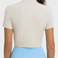 Back view of the Millennia Quarter Zip Short Sleeve Active T-Shirt in cream, showing short sleeves and a cropped style.