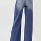 Back view of model wearing High Rise Wide Leg Jeans that elongate legs. Stylish Risen Jeans provide comfort and a flattering fit.