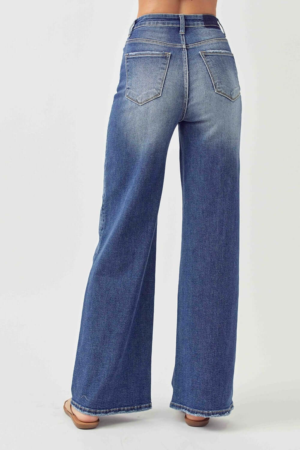 Back view of model wearing High Rise Wide Leg Jeans that elongate legs. Stylish Risen Jeans provide comfort and a flattering fit.