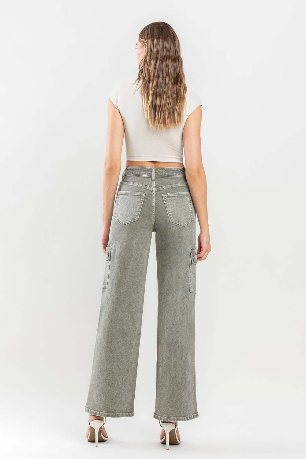 Woman wearing '90s super high rise cargo jeans with loose fit and cargo pockets, showcasing a trendy vintage style from the back view