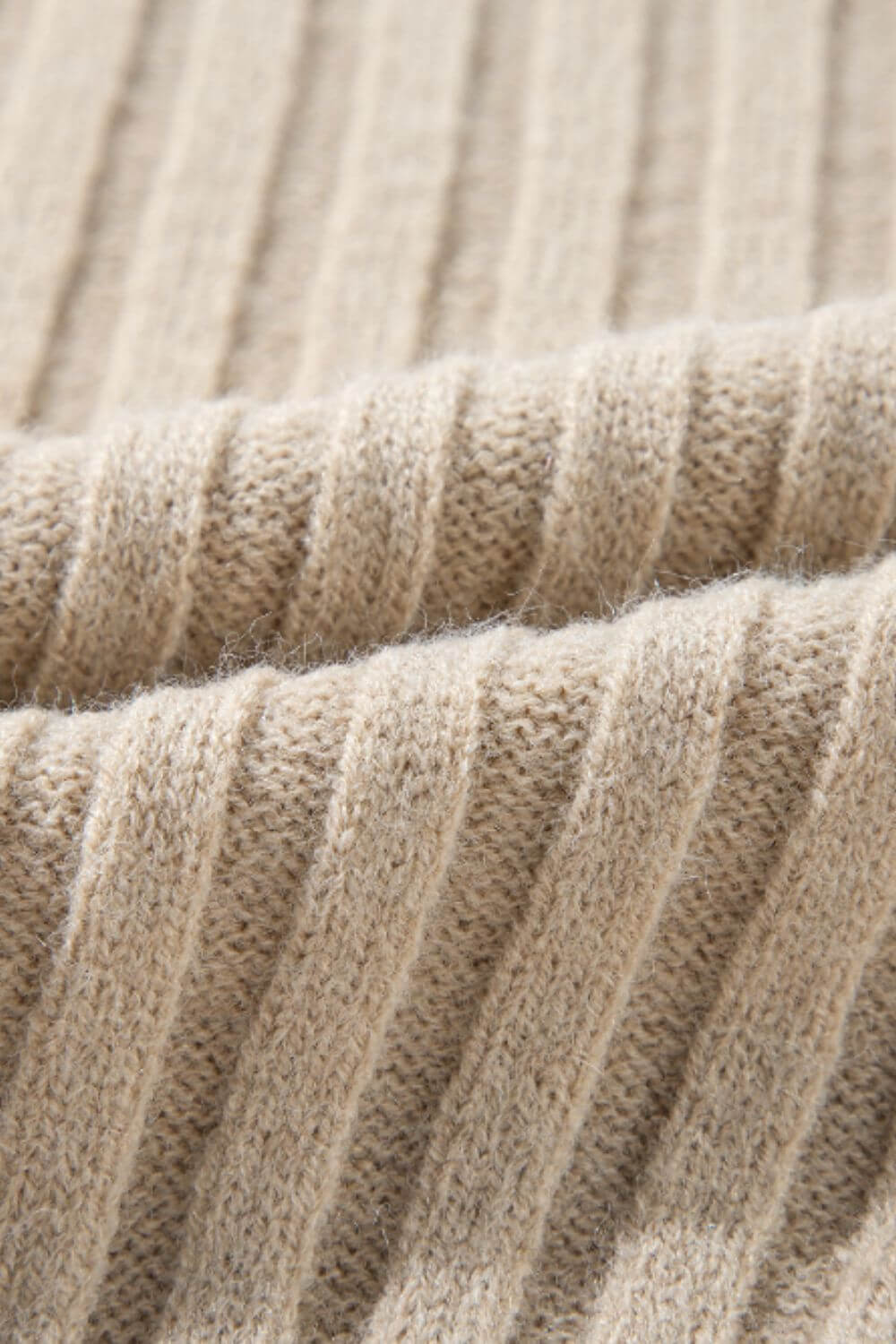 Close-up of tan cable-knit fabric from Bella Road Color Block Round Neck Sweater