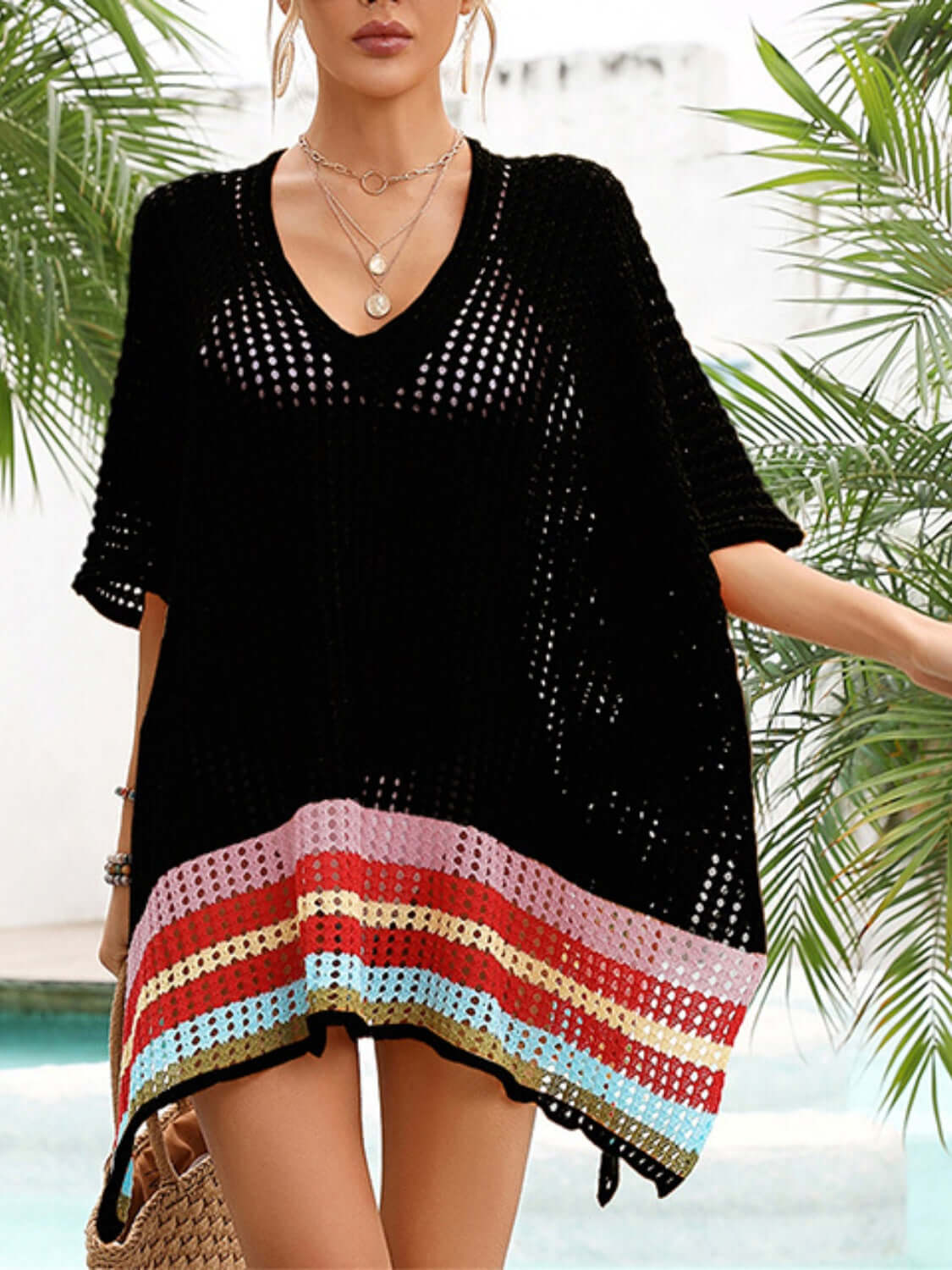 Woman wearing black slit openwork V-neck half sleeve cover-up with colorful hem, made of 100% polyester, by a pool.