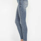 Woman wearing Judy Blue full size tummy control contrast wash skinny jeans with white sneakers.