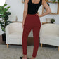 Woman wearing FAM-FAM red high waist skinny pants, showing chic back view. Perfect for versatile and effortless style.