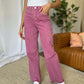 Woman wearing RFM Full Size High Rise Garment Dye Wide Leg Jeans in pink, paired with a white top and white sneakers.