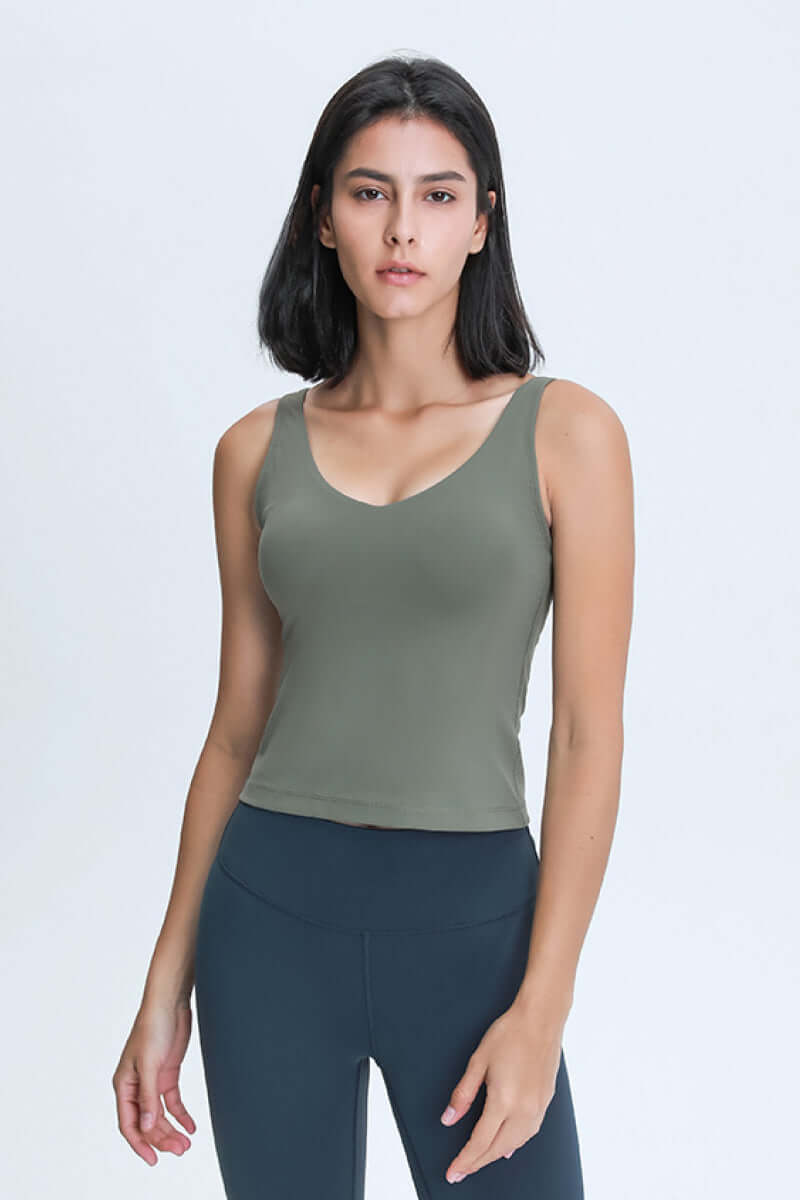 Stylish model wearing a Millennia V Neck Active Tank in olive green, perfect for workouts and athleisure.