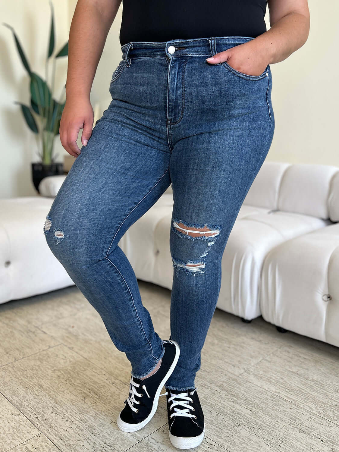 Woman wearing high waist distressed skinny jeans from Judy Blue Jeans, featuring stretchy denim fabric and a flattering fit.