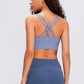 Woman in a blue Millennia Double X Sports Bra showcasing stylish double X strappy back and matching shorts.