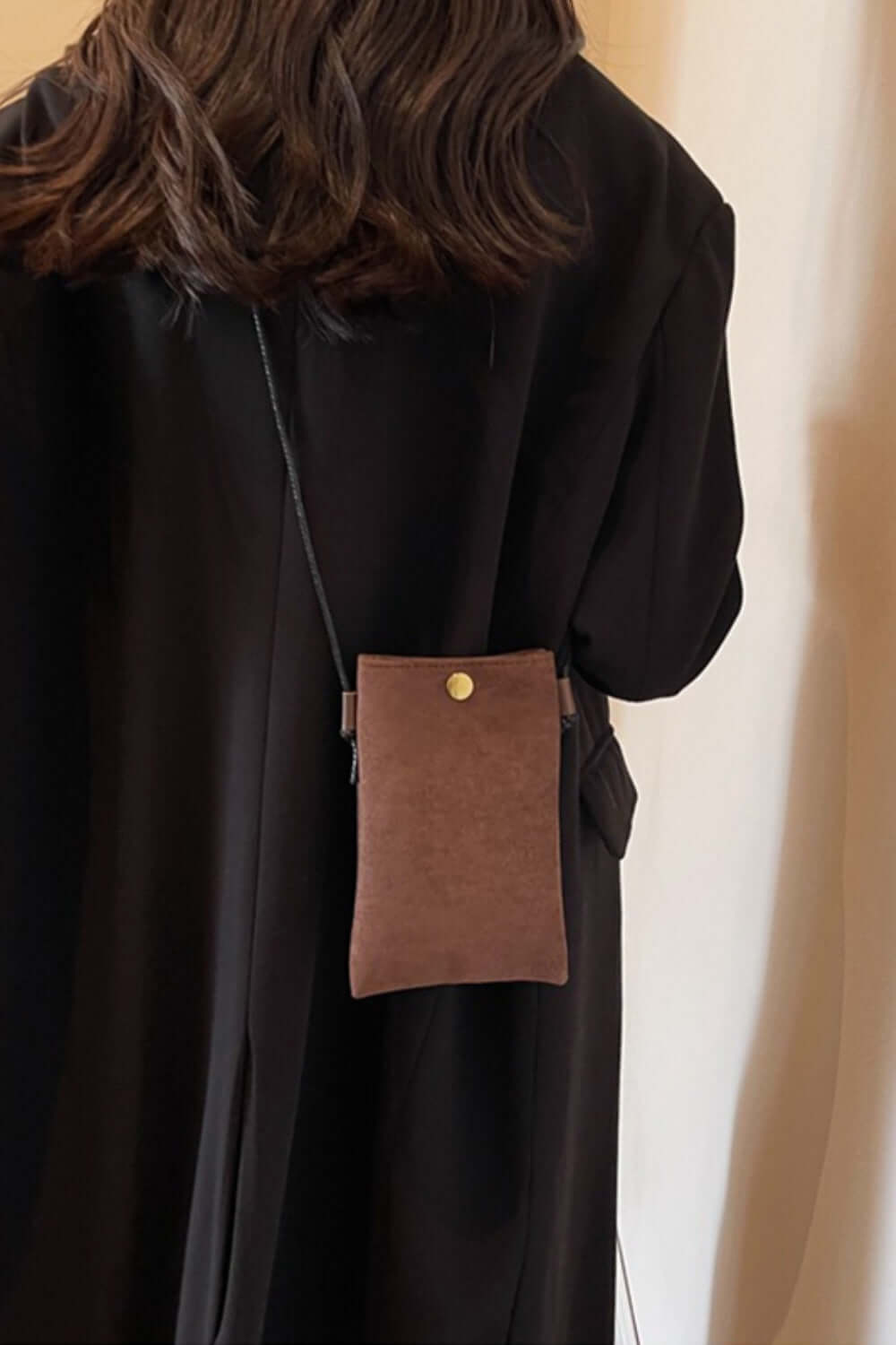 Bella Road Suede Snap Down Crossbody Bag worn on a woman's back with a black outfit.