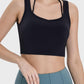 Stylish woman in a black crisscross square neck active tank, perfect for workouts and casual wear.