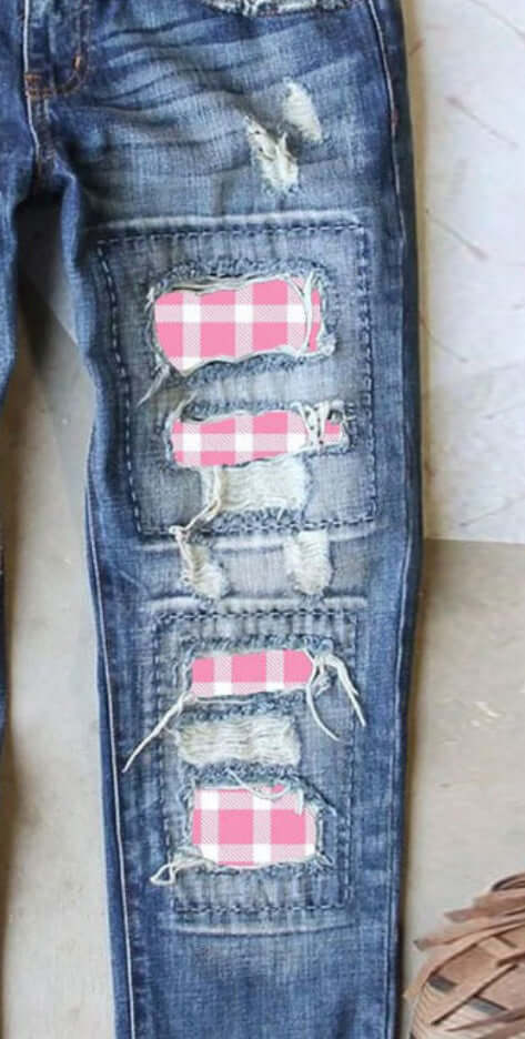 Distressed printed straight jeans with pink and pumpkin plaid patches, showcasing a unique edgy design for a stylish denim collection.