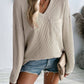 Woman wearing a Double Take Pocketed Textured V-Neck Long Sleeve T-Shirt paired with denim shorts and holding a clutch.