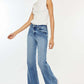 Woman wearing Kancan high-rise wide leg jeans and white top, showcasing a stylish and comfortable look with flare denim.