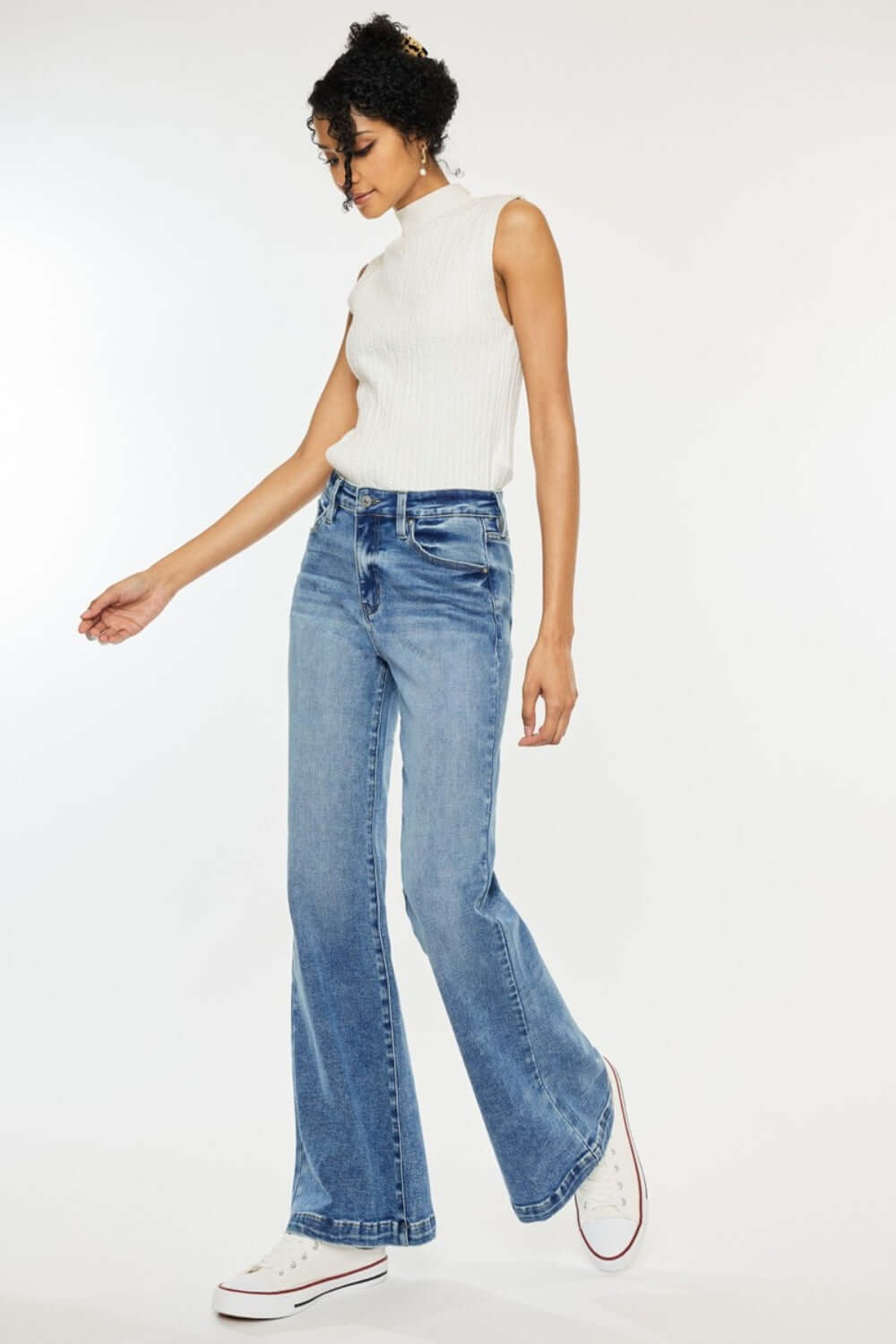 Woman wearing Kancan high-rise wide leg jeans and white top, showcasing a stylish and comfortable look with flare denim.