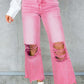 Woman wearing pink distressed raw hem jeans with pockets, featuring ripped knees and a casual, trendy look.