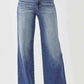 Woman wearing Risen Jeans high rise wide leg jeans with flattering high waist design for a chic and stylish look.