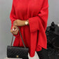 Woman wearing cozy Bella Road Round Neck Batwing Sleeve Sweater in vibrant red, holding a stylish black quilted handbag.