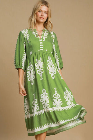 Model wearing a trendy green printed notched midi dress, perfect for casual or semi-formal occasions.