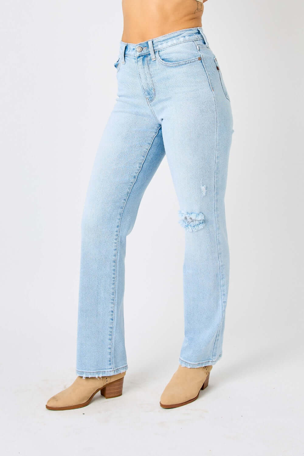 Woman wearing high waist distressed straight Judy Blue jeans full size with knee rip, paired with tan heeled boots.