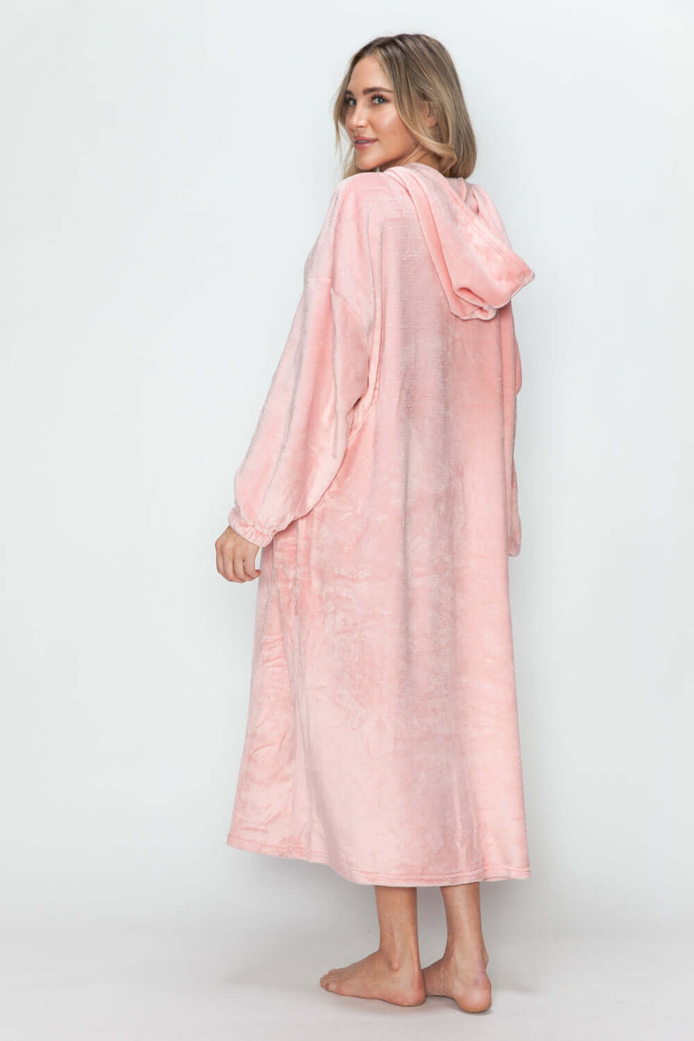 Stylish woman in a dusty pink hooded midi dress, showcasing a cozy design with pockets, perfect for lounging this fall.