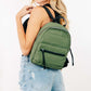 Stylish woman wearing an adjustable strap olive green nylon backpack, showcasing its modern design and practicality.