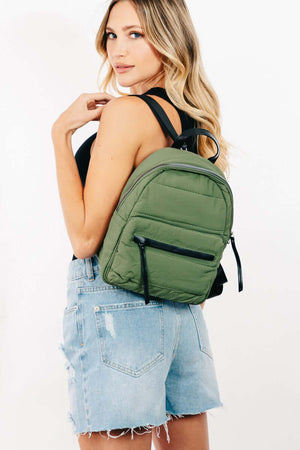 Stylish woman wearing an adjustable strap olive green nylon backpack, showcasing its modern design and practicality.