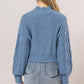 Stylish blue cable-knit mock neck sweater with dropped shoulders, perfect for cozy fall outfits.