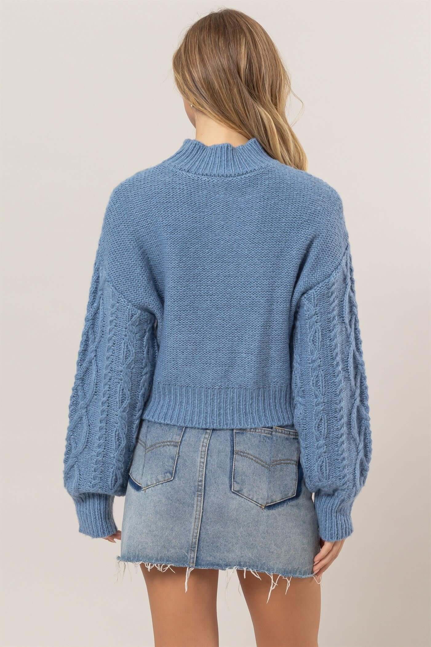 Stylish blue cable-knit mock neck sweater with dropped shoulders, perfect for cozy fall outfits.