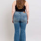 Woman showcasing Judy Blue mid rise tummy control vintage wash jeans from the back, highlighting the retro style and fit.