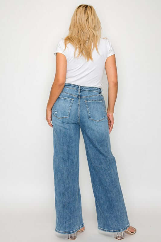 Woman in a white t-shirt wearing bytos high rise wide leg jeans with pockets, showcasing a stylish back view.