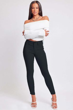 Model wearing YMI Jeans Hyperstretch Mid-Rise Skinny Pants paired with a white off-shoulder top and heels.