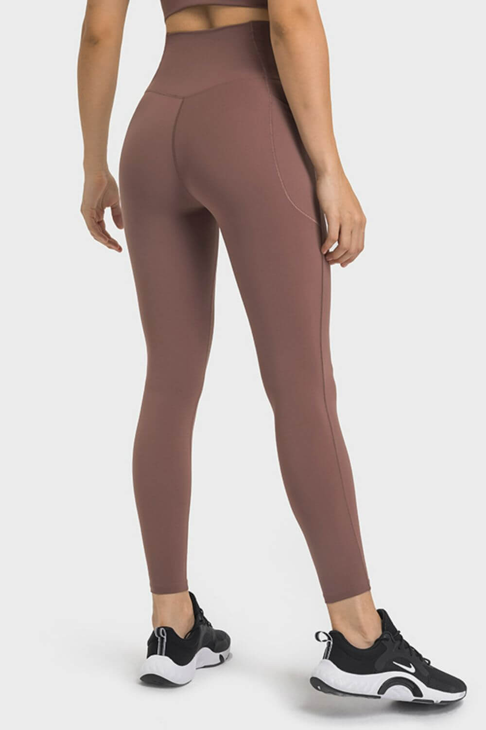 Stylish Millennia V-Waist Yoga Leggings with pockets, perfect for workouts and everyday wear in a solid brown color.