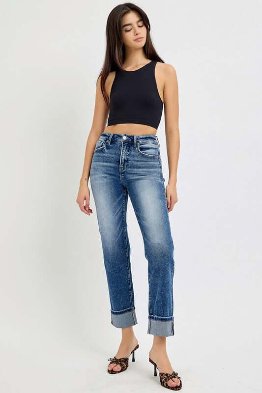 Model wearing RISEN Full Size High Rise Crop Straight Roll Up Jeans with a black crop top and stylish heels.