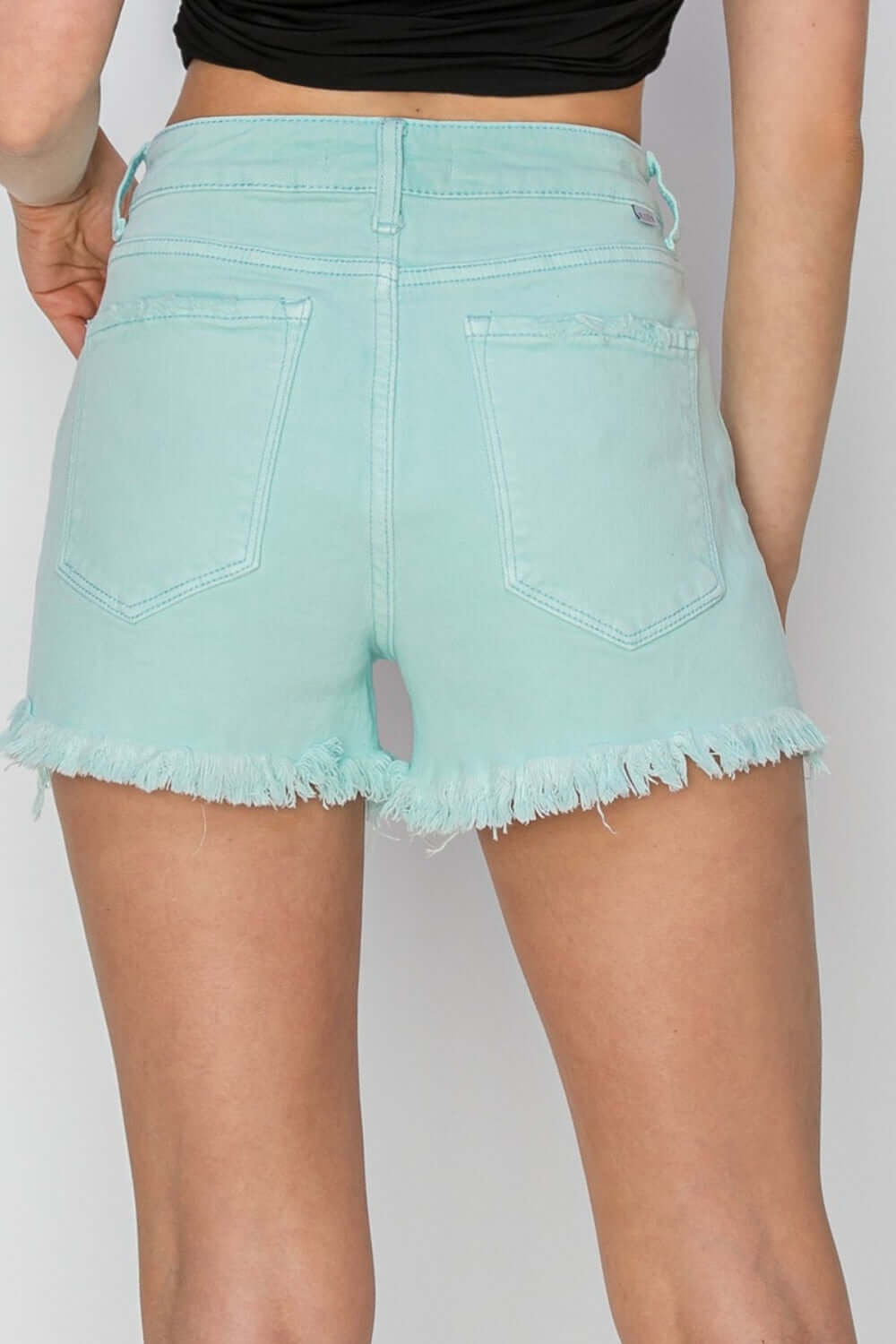 Mid Waist Frayed Hem Denim Shorts in light blue by Risen Jeans, showcasing the stylish frayed hem from the back. Perfect summer fashion!