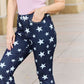 Woman wearing Janelle Full Size High Waist Star Print Flare Jeans by Judy Blue Jeans, showcasing dark wash finish and unique star design.