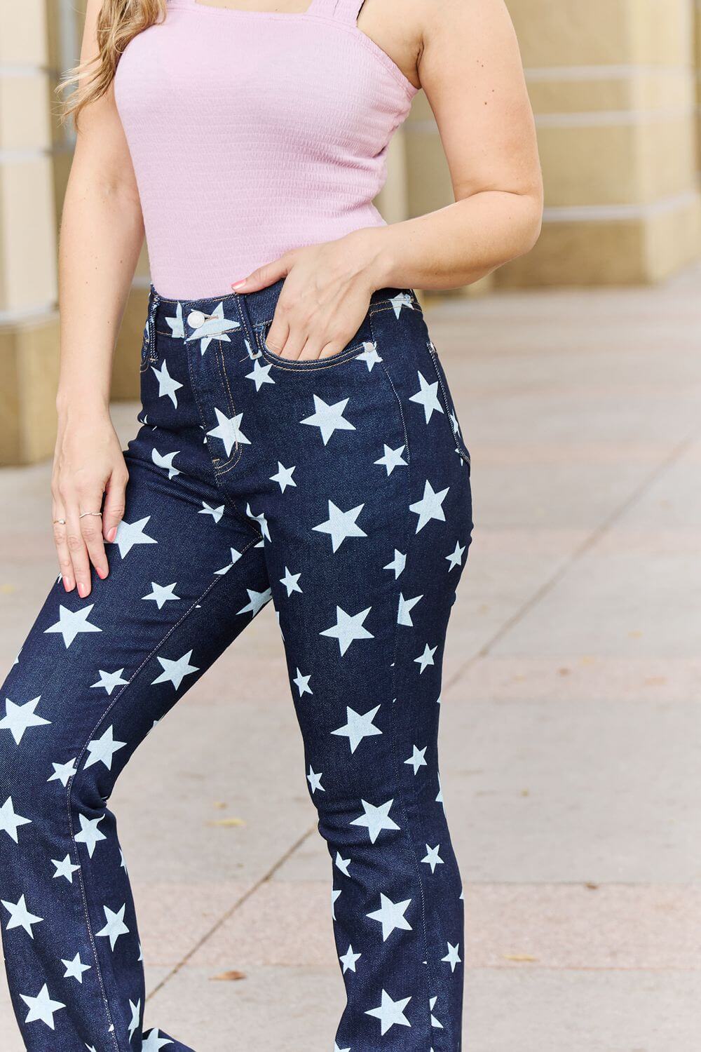 Woman wearing Janelle Full Size High Waist Star Print Flare Jeans by Judy Blue Jeans, showcasing dark wash finish and unique star design.