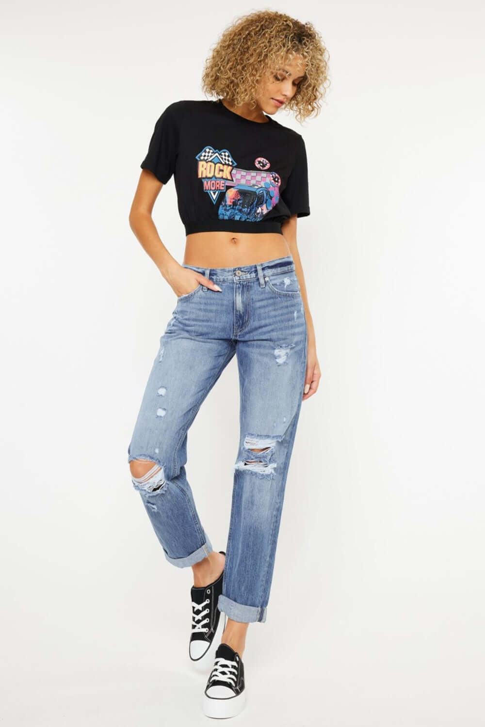 Mid rise distressed straight jeans paired with a black graphic tee and black sneakers, showcasing an edgy and stylish urban look.