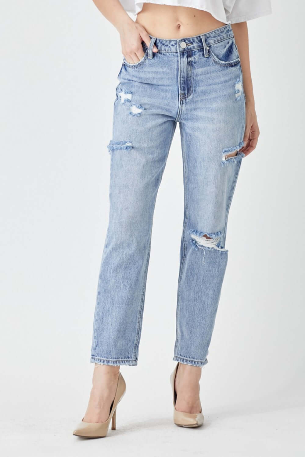 Stylish distressed slim cropped Risen Jeans with edgy detailing, perfect for a trendy and chic look, paired with beige heels.