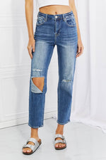 Model wearing Emily High Rise Relaxed Jeans with ripped knee details, a casual and edgy wardrobe staple from Risen Jeans.