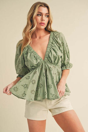 Chic green eyelet embroidered V-neck half sleeve peplum blouse paired with shorts for a stylish look.