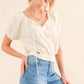 Woman wearing the Back Waist Tie Cropped Blouse with a stylish back tie detail, paired with high-waisted jeans for a trendy look.