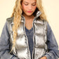 Woman wearing VERY J Shiny Metallic Zip Up Puffer Vest with high neck and side pockets, showing the vest’s stylish and practical design