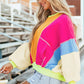 Woman wearing Bella Road Color Block Round Neck Long Sleeve Top with vibrant blocks of pink, yellow, blue, and beige.