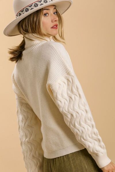 Cozy cream turtle neck long sleeve sweater with cable knit sleeves, perfect for winter styling in plus sizes.