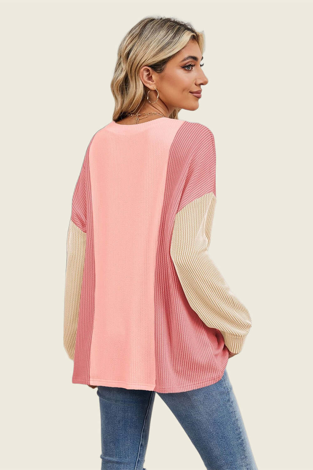 Woman wearing pink and beige Double Take Texture Contrast Round Neck Long Sleeve T-Shirt with jeans, viewed from the back