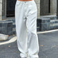 Bella Road white wide-leg jeans with pockets, low waist, slightly stretchy, made of 85% cotton and 15% polyester, modeled outdoors.