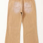 Tan distressed raw hem jeans with pockets viewed from the back